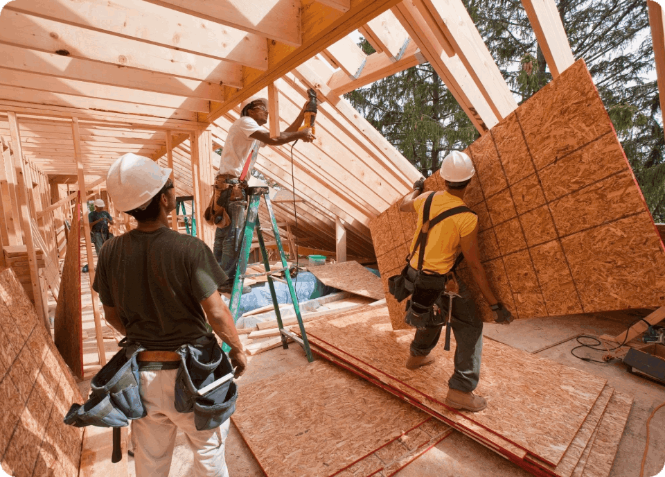A group of men working on the roof of a house.